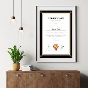 May include: A black and gold certificate of appreciation with a red ribbon. The certificate is presented to Aaron Paul for their outstanding contributions, dedication, and commitment to excellence. The certificate is dated November 24, 2023.