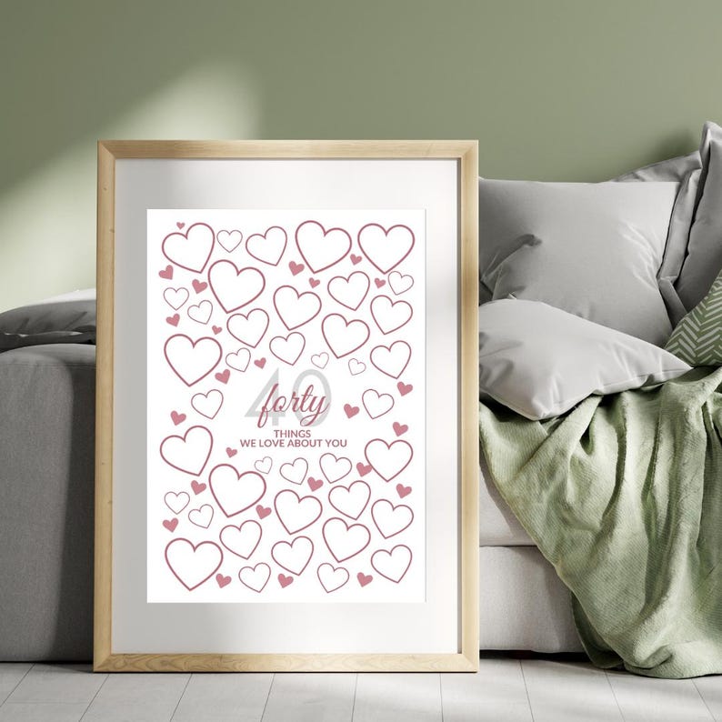 May include: A framed print with a white background featuring numerous pink heart outlines. The word "forty" is in a cursive font, with the text "things we love about you" below it. The frame is a light wood color.