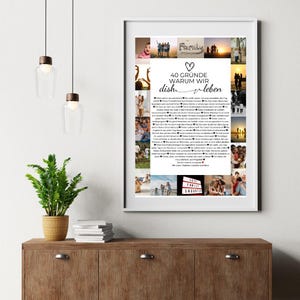 May include: A framed print with a white border, featuring a collage of family photos surrounding a central text. The text reads "40 GR&Uuml;NDE WARUM WIR dish v leben" in German. The print is displayed on a wooden cabinet with a plant and hanging lights.