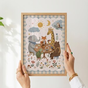 May include: A framed wall art print featuring a light blue and white gingham border. The illustration depicts an elephant, fox, giraffe, turtle, and bear sitting around a round table for tea, surrounded by flowers, mushrooms, a sun, and moon.