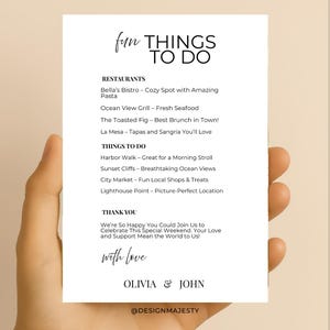 K&ouml;nnte beinhalten: Eine wei&szlig;e Karte mit dem Text "fun THINGS TO DO" in einer handschriftlichen Schriftart. Die Karte listet Restaurants und Aktivit&auml;ten auf, darunter "Bella's Bistro", "Harbor Walk" und "Sunset Cliffs". Die Karte enth&auml;lt auch die Namen "OLIVIA & JOHN".