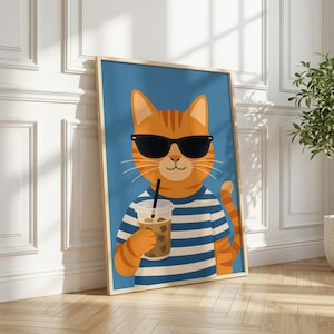 May include: A framed vertical wall art print featuring an orange tabby cat wearing black sunglasses and a blue and white horizontal striped shirt. The cat is holding a clear plastic cup filled with an iced coffee beverage with a black straw.