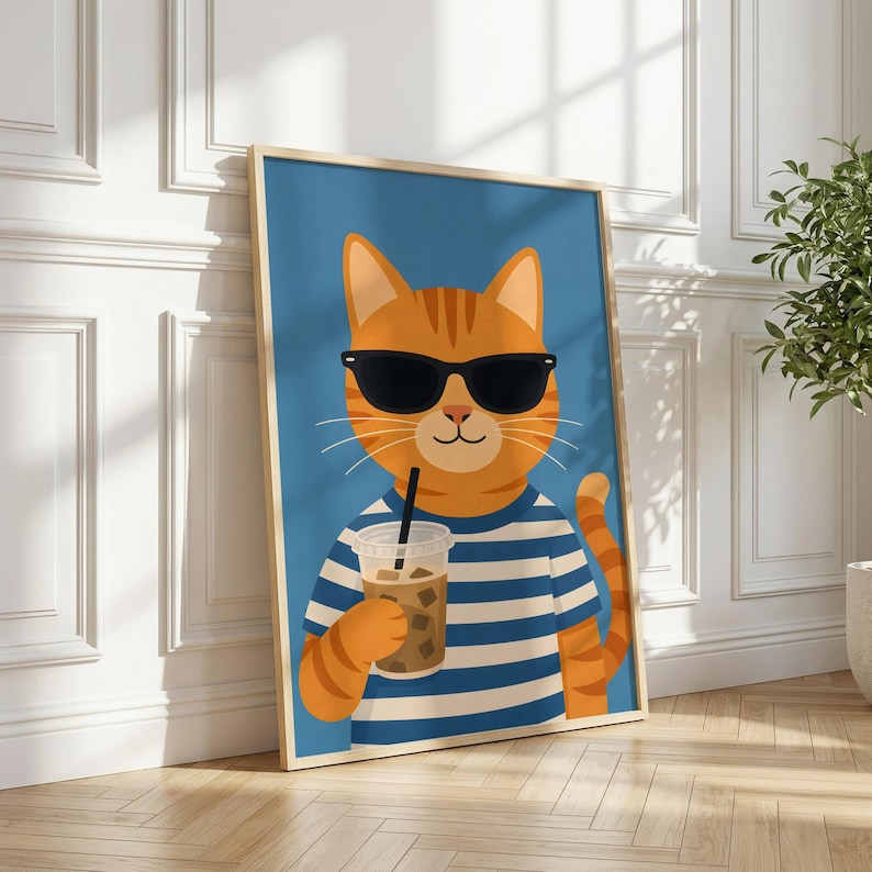 May include: A framed vertical wall art print featuring an orange tabby cat wearing black sunglasses and a blue and white horizontal striped shirt. The cat is holding a clear plastic cup filled with an iced coffee beverage with a black straw.