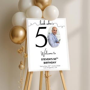 May include: White welcome sign with black text and a photo of a person. The text reads "Look who's 50. Welcome to Steven's 50th Birthday. Saturday 30th June 202X. Los Angeles, CA."