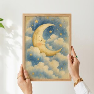Pu&ograve; includere: Una stampa artistica da parete verticale incorniciata raffigurante un'illustrazione ad acquerello di una luna crescente sorridente con occhi chiusi e guance rosee, immersa tra soffici nuvole in un cielo notturno blu profondo punteggiato di stelle gialle.