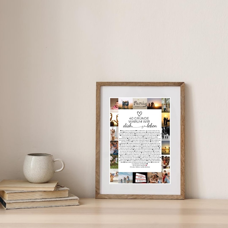 May include: A framed print with a wooden frame, featuring a collage of photos and text in German. The text reads "40 Gr&uuml;nde warum wir dich lieben" (40 reasons why we love you). A mug and books are in the foreground.