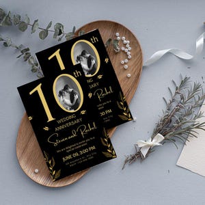 May include: Black and gold wedding anniversary invitations with a photo of a couple. The invitations feature the text "10th Wedding Anniversary" and the names "Steven and Rachel". The invitations are on a wooden tray with decorative elements.