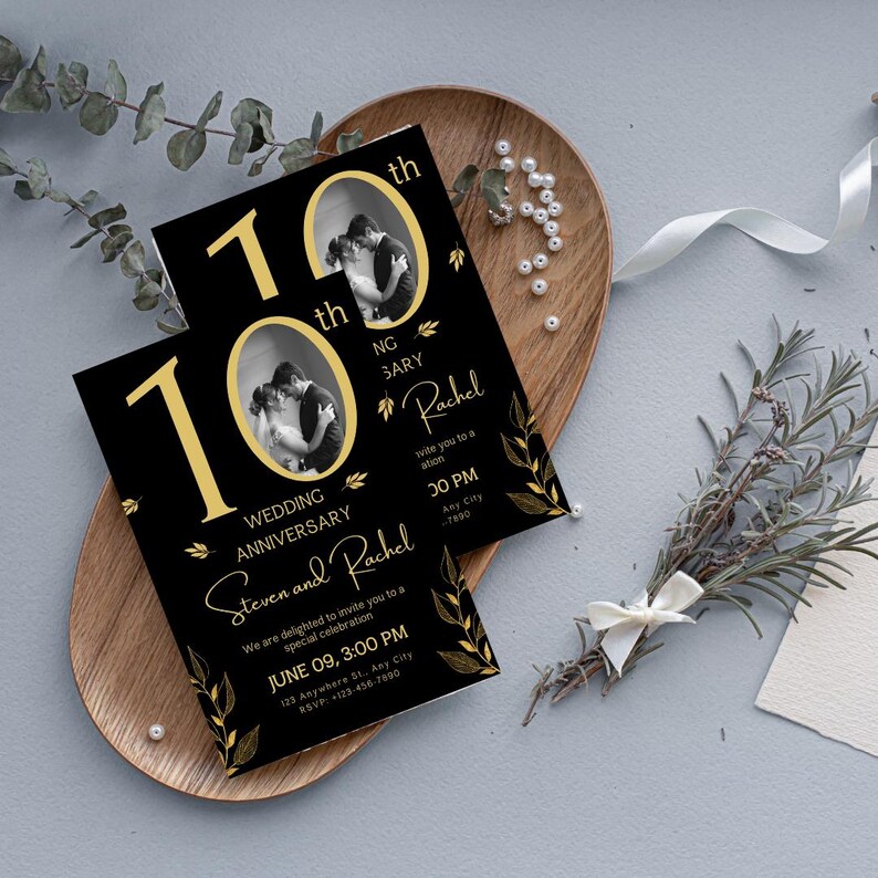 May include: Black and gold wedding anniversary invitations with a photo of a couple. The invitations feature the text "10th Wedding Anniversary" and the names "Steven and Rachel". The invitations are on a wooden tray with decorative elements.