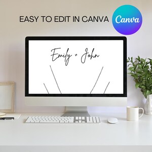 以下が含まれることがあります： 白いコンピューター画面に「Emily + John」というテキストが表示されています。画面は、キーボード、マウス、白いマグカップのある白い机の上にあります。