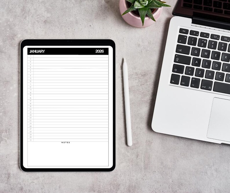Op de afbeelding: Een digitale planner op een zwarte tablet, met een kalenderindeling voor januari 2026 met gelijnde secties voor notities. Een witte stylus ligt naast de tablet. Een laptop en een kleine potplant zijn ook zichtbaar op een grijze ondergrond.