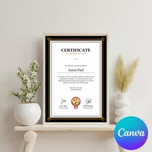 May include: A black and gold framed certificate of appreciation with a gold seal and red ribbon. The certificate is presented to Aaron Paul for their outstanding contributions, dedication, and commitment to excellence. The certificate is dated November 24, 2015.