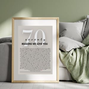 May include: A framed print with a beige background and the number 70 in white. The text "seventy reasons we love you" is below the number. The print features a list of reasons in black text.
