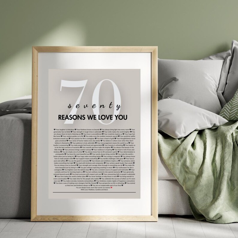 May include: A framed print with a beige background and the number 70 in white. The text "seventy reasons we love you" is below the number. The print features a list of reasons in black text.