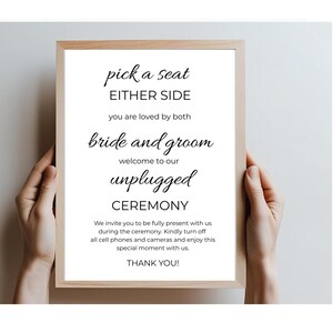 May include: A white sign with black text that reads "pick a seat either side you are loved by both bride and groom welcome to our unplugged ceremony we invite you to be fully present with us during the ceremony kindly turn off all cell phones and cameras and enjoy this special moment with us thank you!"