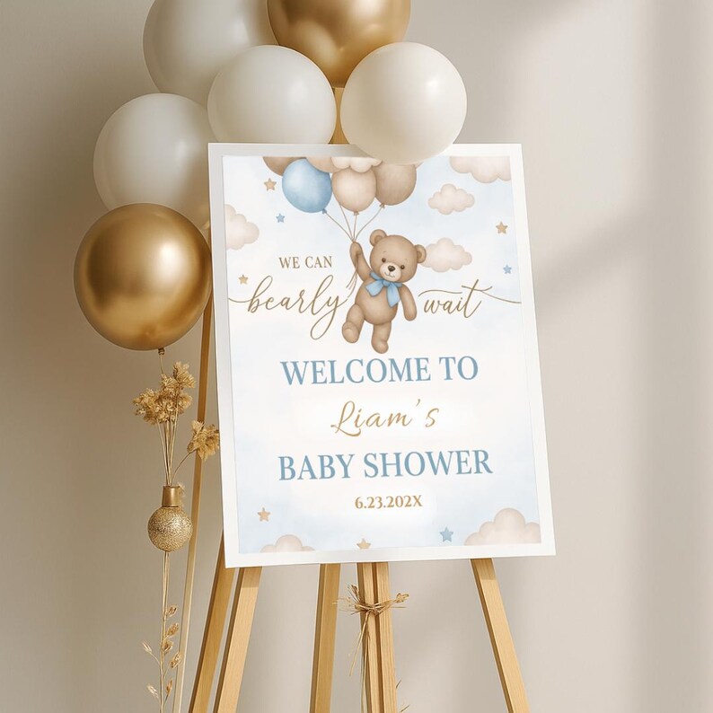 May include: A blue and white baby shower welcome sign with a teddy bear holding balloons. The sign says "We can bearly wait" and "Welcome to Liam's Baby Shower 6.23.202X".