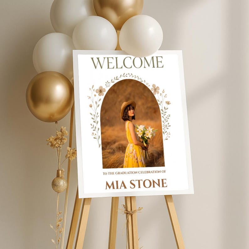May include: Welcome sign with a floral arch and a photo of a woman in a yellow dress holding flowers. The sign says "Welcome to the graduation celebration of Mia Stone".