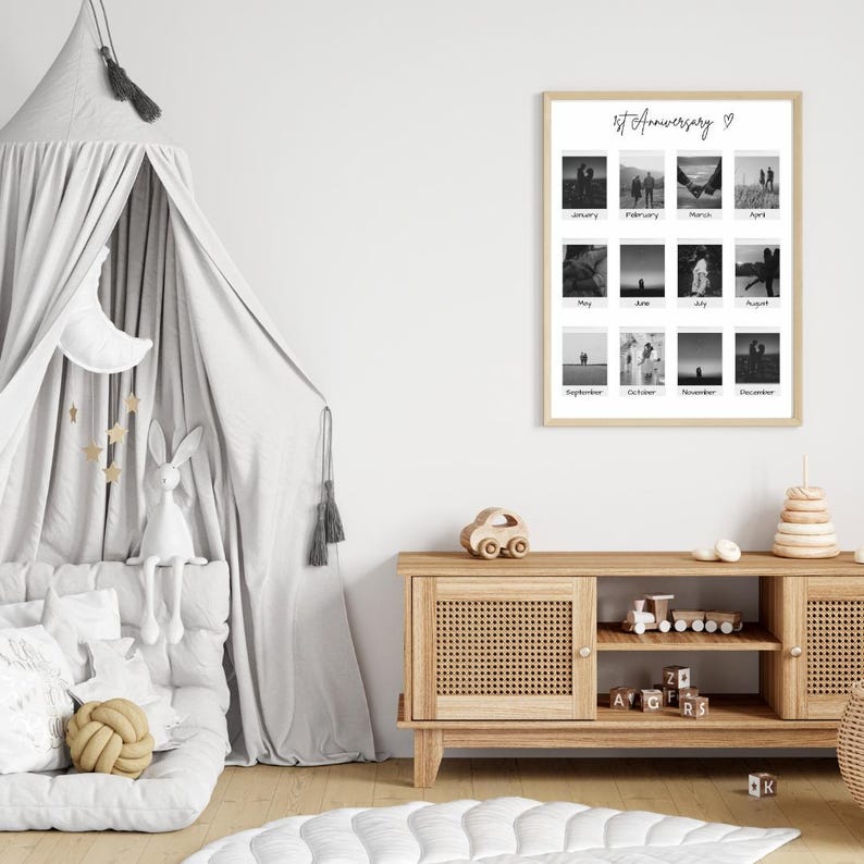May include: A black and white photo collage of a couple's first year of marriage. The collage is framed in a white frame and hangs on a white wall. The collage is titled "1st Anniversary".