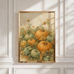 May include: A framed wall art print featuring a watercolor-style illustration of several pumpkins in shades of orange and muted green, surrounded by detailed foliage, vines, and small yellow flowers against a soft, neutral, cream-colored background.