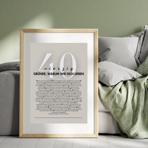 Puede incluir: Un cuadro enmarcado con el texto "40 razones por las que te amamos" en alem&aacute;n. La impresi&oacute;n tiene un fondo beige claro con grandes n&uacute;meros blancos y texto en una fuente serif. El marco es de color madera clara.
