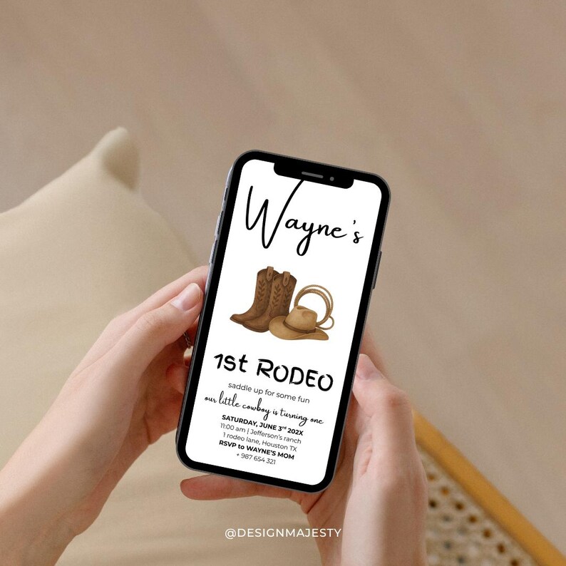 May include: A smartphone displays a rodeo-themed invitation. The invitation features brown cowboy boots, a hat, and a lasso. Text includes "Wayne's 1st Rodeo" and event details. The phone is held by a person.