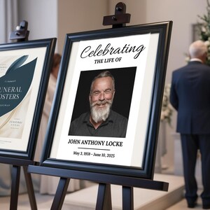 Pu&ograve; includere: Un cavalletto nero con un poster bianco. Il poster contiene una foto in bianco e nero di un uomo con la barba su uno sfondo bianco. Il testo sul poster recita "Celebrating the Life of John Anthony Locke May 3, 1959 - June 10, 2025".