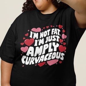May include: Black t-shirt with a pink and white graphic that says "I'm not fat, I'm just amply curvaceous" surrounded by pink hearts.