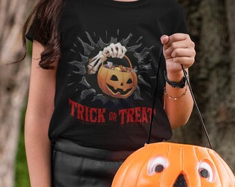 May include: A young person dressed as a witch for Halloween, wearing a black witch hat, a black shirt with a pumpkin and the text "Trick or Treat", and a black skirt. They are holding an orange pumpkin-shaped trick-or-treat bag.