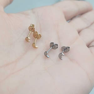 May include: Two pairs of crescent moon earrings, one pair is gold and the other is silver.