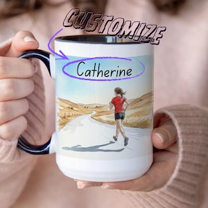 May include: White ceramic mug with a black handle and rim, featuring a watercolour illustration of a runner on a road. The mug is personalised with the name "Catherine" and the word "Customize". The background shows a landscape with a road and hills.