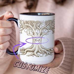 Peut inclure: Mug en céramique blanche avec une anse et un bord noirs, orné d'une illustration détaillée d'un arbre avec des racines et des branches. Le motif de l'arbre comprend un cœur avec des initiales. Le mot "CUSTOMIZE" est en bas.