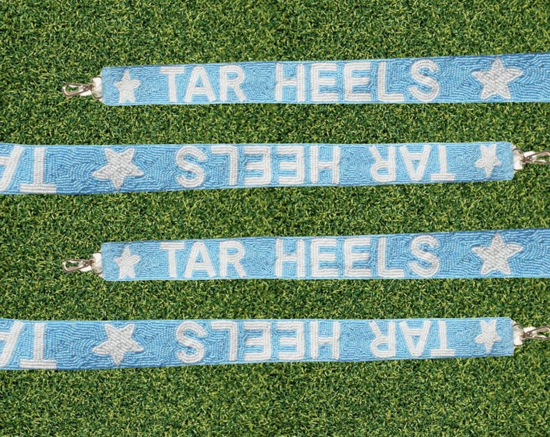 May include: Four light blue beaded straps with white beads spelling "TAR HEELS" and a white star at the end of each strap.