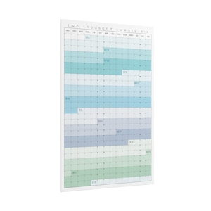 Op de afbeelding: Een verticale wandkalender voor het jaar 2026, met een rasterindeling die de maanden weergeeft. De kalender heeft een witte rand en gebruikt blauwe en groene tinten voor elke maand. De tekst "two thousand twenty-six" staat bovenaan.