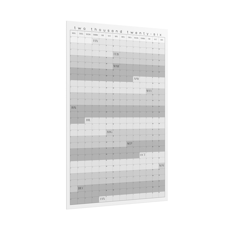 Op de afbeelding: Een grote, rechthoekige kalender voor 2026 in grijstinten en wit. De kalendergrid is verdeeld in maanden en dagen, met de titel van het jaar bovenaan. De maanden zijn gelabeld en het algehele ontwerp is minimalistisch en modern.