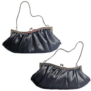 May include: Two black satin evening bags with silver chain straps and a silver clasp closure.