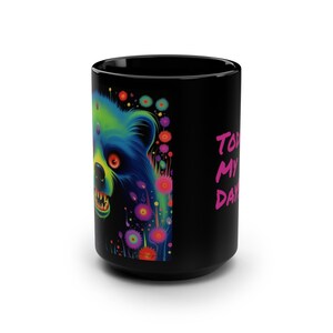 May include: Black ceramic mug featuring a colorful illustration of a bear with neon green, blue, and yellow hues. The bear has an open mouth with visible teeth. The mug also has the text "Today is My Day" in pink.