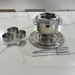 Set da fonduta vintage in acciaio inox completo di bruciatore, forchette, tazze e mestolo.