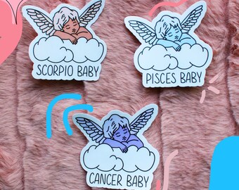 May include: Three sticker designs featuring a sleeping cherub with wings on a cloud. Each sticker has a different color scheme and includes the text "Scorpio Baby", "Pisces Baby", and "Cancer Baby".