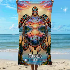 May include: Beach towel featuring a colorful turtle design with a sunset scene inside its shell. The towel has the text "RIVER LAKE TAHOE 2026" at the bottom. The artwork is vibrant with blues, oranges, and greens.