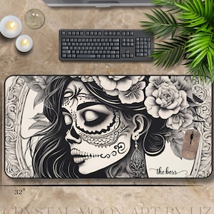 May include: A black and white desk mat featuring a sugar skull design with floral accents. The mat is rectangular, measuring 32 inches long and 16 inches wide. The words "the boss" are written on the mat.