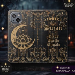 May include: Black phone case with gold floral and celestial designs. Features a crescent moon, lotus flower, and the name "Suzan" in gothic script. Text includes "Herbs, Spells, Rituals" and "Grimoire of Suzan". Includes a built-in phone stand and custom personalization.