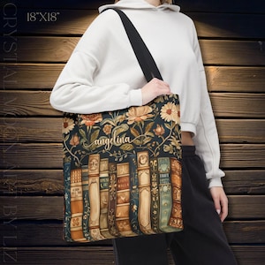May include: A tote bag with a floral and book design. The bag is 18" x 18" and features a dark background with flowers and vintage-style book spines. The name "angelina" is written in cursive. The bag has a black strap.