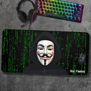 May include: A black and green mousepad with a digital green code pattern. A black hooded figure with a white mask is in the center of the mousepad. The text "Guy Fawkes" is in the bottom right corner of the mousepad.
