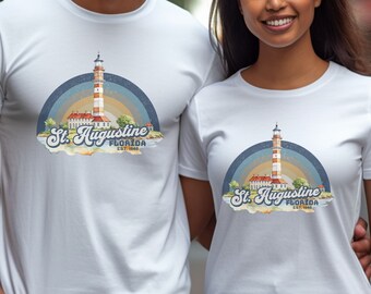 May include: White t-shirt with a graphic of a lighthouse and the text "St. Augustine, Florida Est. 1565" in a vintage style.