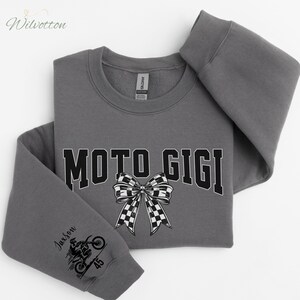 May include: A gray sweatshirt with the text "MOTO GIGI" in black block letters and a checkered bow graphic. The left sleeve features a motorcycle graphic and the name "Jaxson" with the number "45".