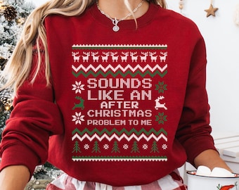 Op de afbeelding: Een kardinaalrood sweatshirt met een feestelijk ontwerp. Het ontwerp bevat rendieren, sneeuwvlokken en kerstbomen, samen met de tekst "SOUNDS LIKE AN AFTER CHRISTMAS PROBLEM TO ME" in wit en groen.