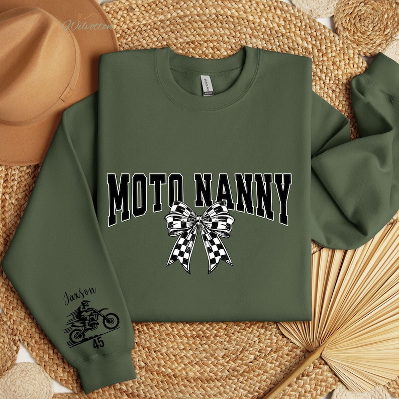 May include: Olive green sweatshirt with the text "MOTO NANNY" in black and white, featuring a checkered bow graphic. The left sleeve has a motorcycle graphic and the name "Jaxson" with the number "45".