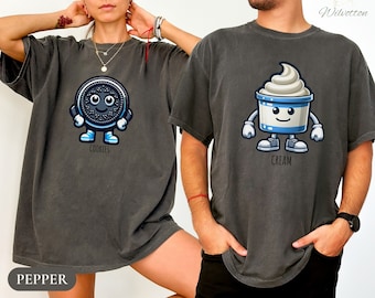 May include: A matching set of two gray t-shirts with a cartoon cookie and ice cream design. The cookie shirt says "Cookies" and the ice cream shirt says "Cream".