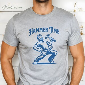 May include: A gray t-shirt with a blue illustration of a man holding a hammer and the text "HAMMER TIME".