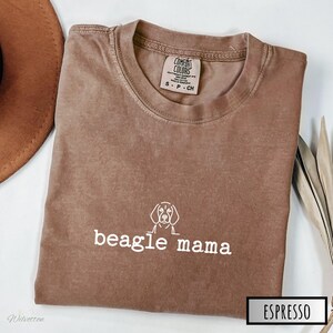 K&ouml;nnte beinhalten: Ein braunes T-Shirt mit einer wei&szlig;en Umrandung eines Beagle-Hundes und dem Text "beagle mama" in wei&szlig;.