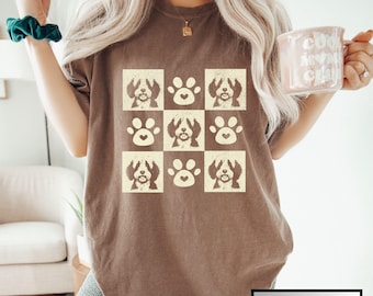 May include: A brown t-shirt with a white graphic of a dog's face and paw prints. The text "ESPRESSO" is in the bottom right corner of the image.
